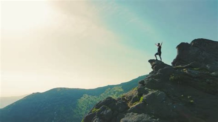 a man standing on top of a bench in a gym