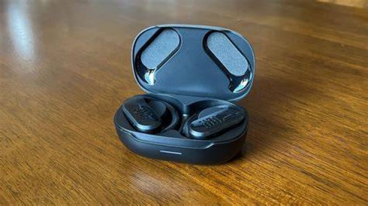 JBL Endurance Peak III in their charging case, hand-held.