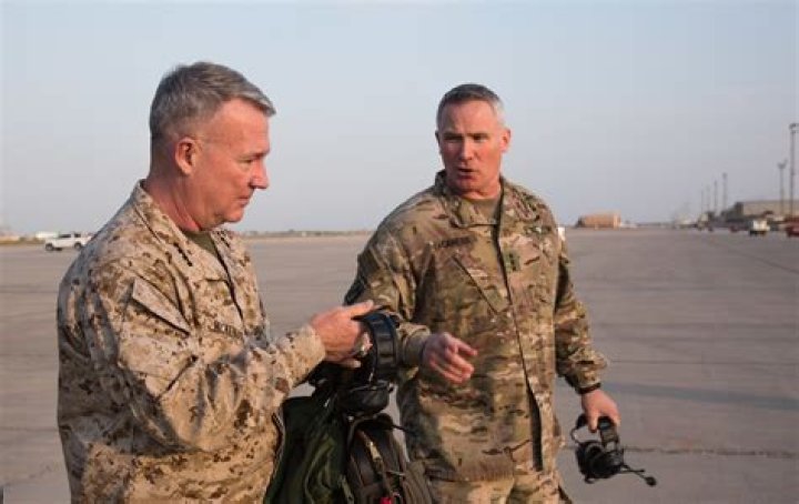 Lt. Gen. McKenzie's wife, Marilyn, and son, pin on his